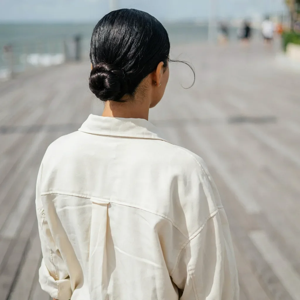 Braided low bun with a middle part for medium length hair